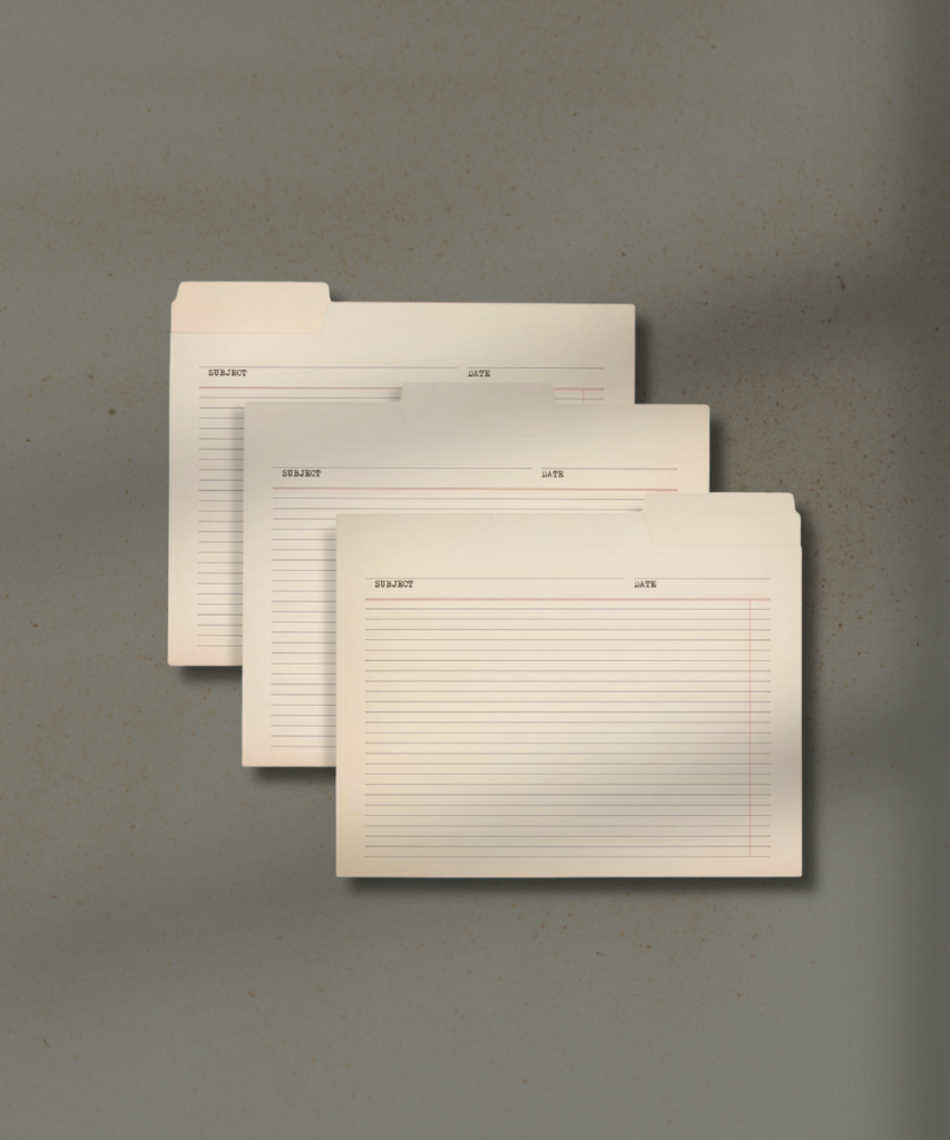 Three beige filing folders with lined index pages and subject/date headers stacked on a textured background